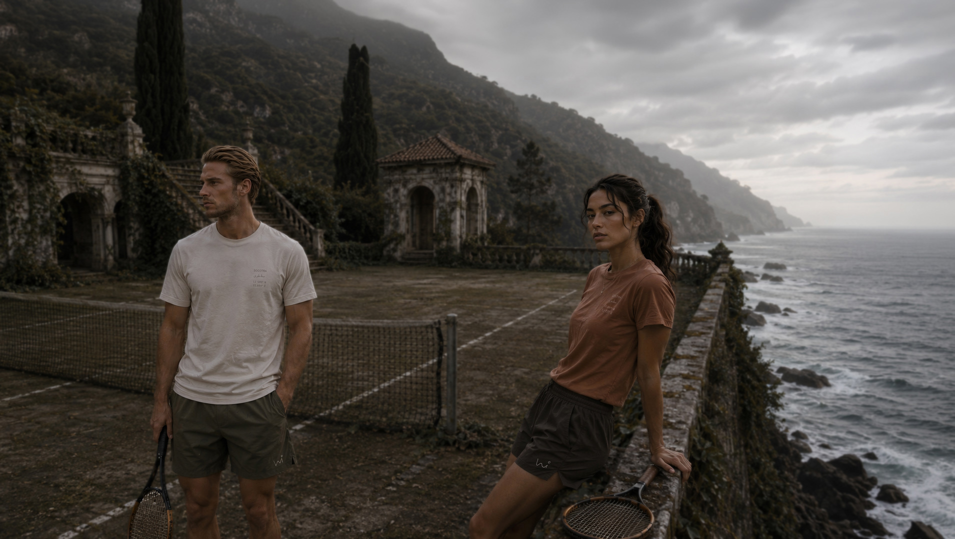 Two people on a clifftop tennis court above the sea